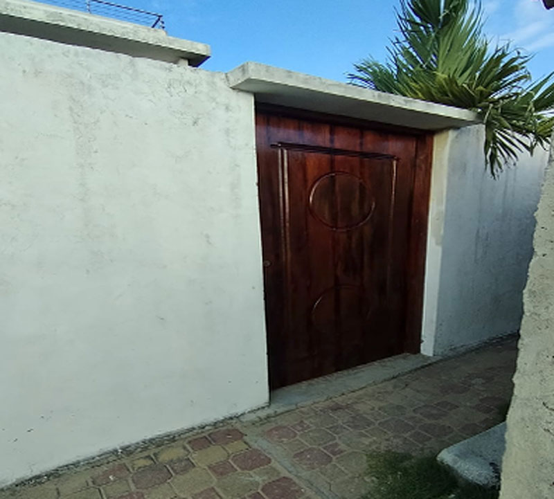 Puerta de salida hacia la playa laqueada y pintada, mejorando su apariencia y protección.